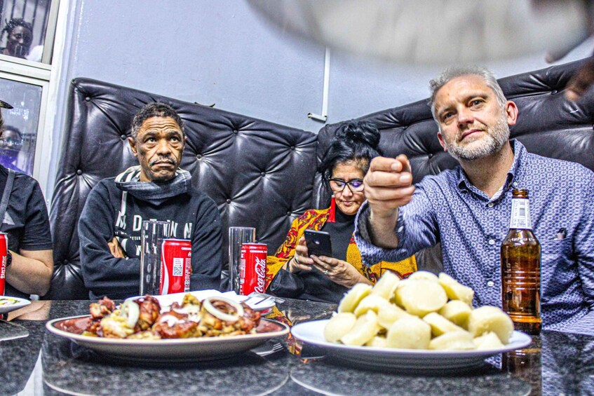 People seated at a table with food and drinks. 4