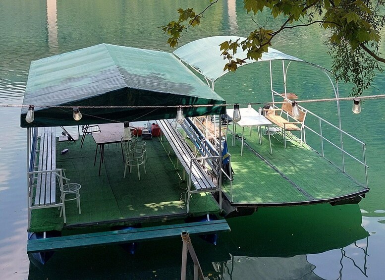 A floating deck with tables and chairs, surrounded by water. 2