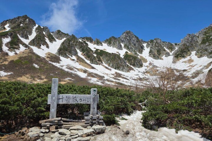 A mountainous landscape with a signpost and a snow-covered path. 1