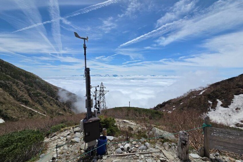 A mountainous landscape with a weather station, electrical tower, and a road. 4