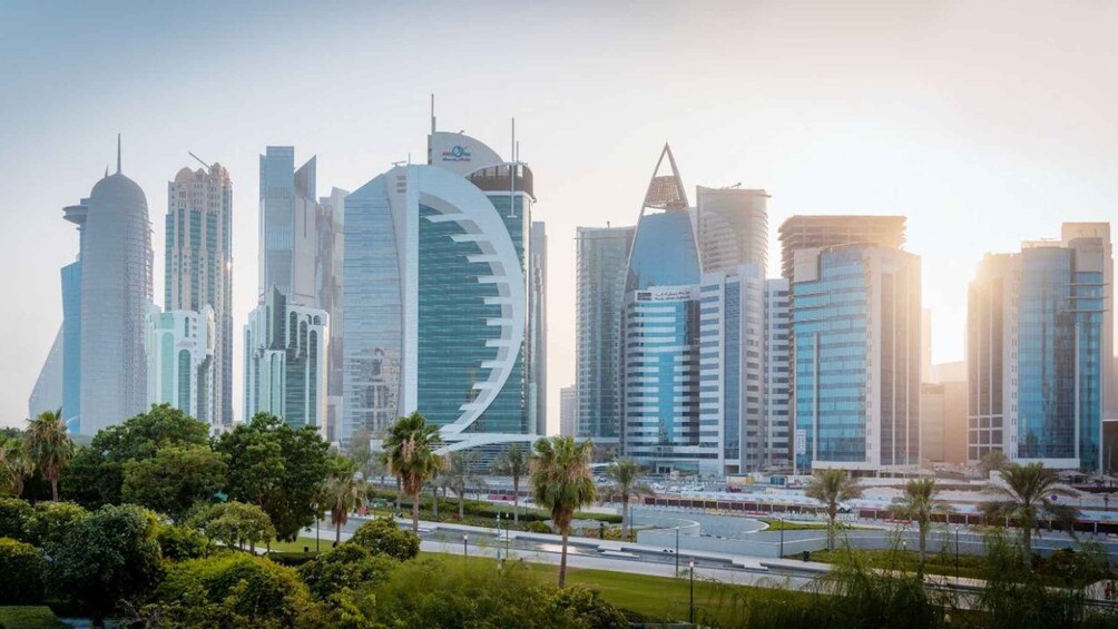 A city skyline with modern skyscrapers, palm trees, and a clear sky. 5