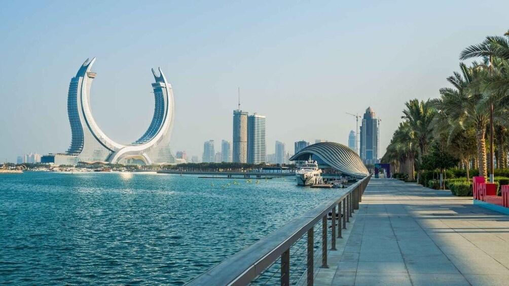 A waterfront promenade with a distinctive curved bridge and modern buildings in the background. 4