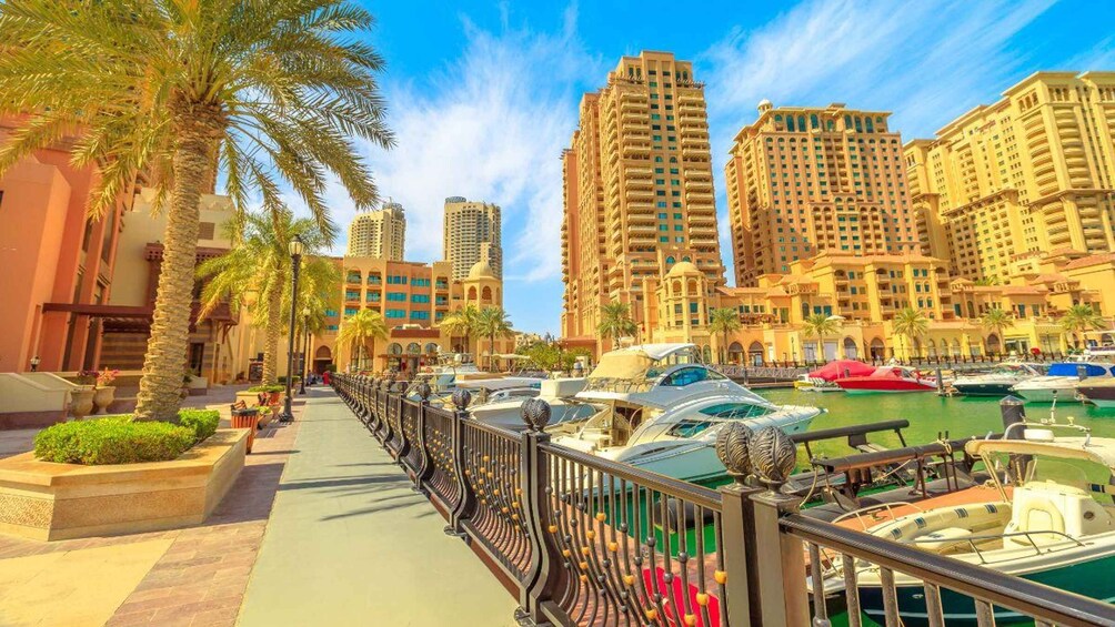 A marina with boats, palm trees, and high-rise buildings. 3