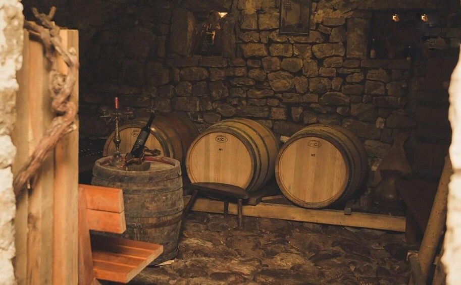 A cellar with wooden barrels and a wooden bench. 5