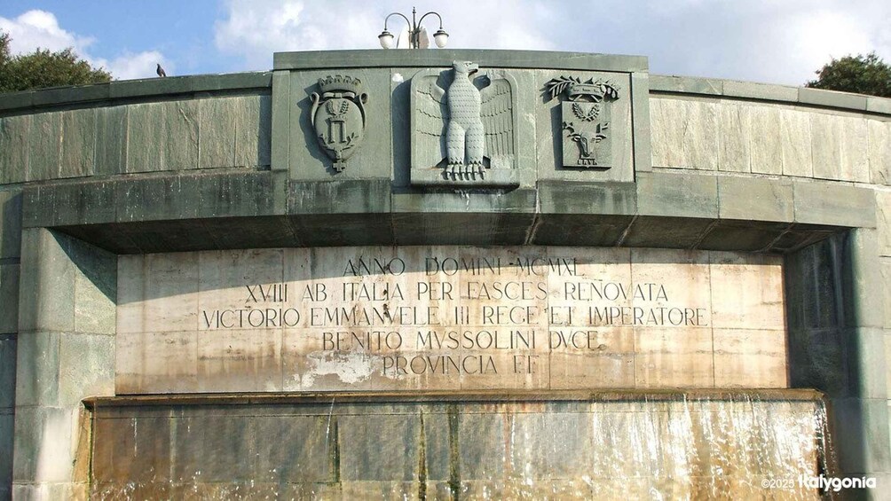 A stone monument with inscriptions and a coat of arms. 2