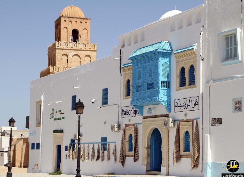 A white building with a blue-tiled window and a tower. 2