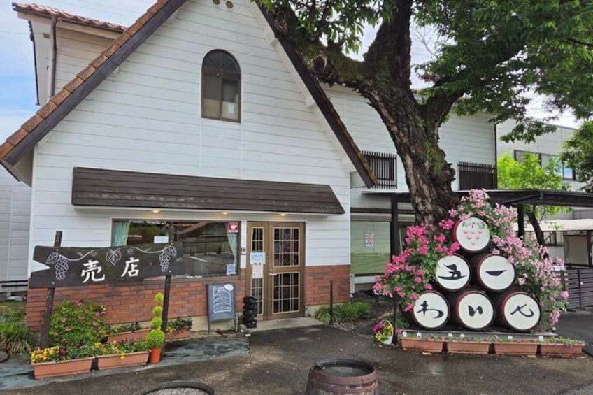 A white building with a sign reading 'KURTEI' and a display of round objects with Japanese characters. 5