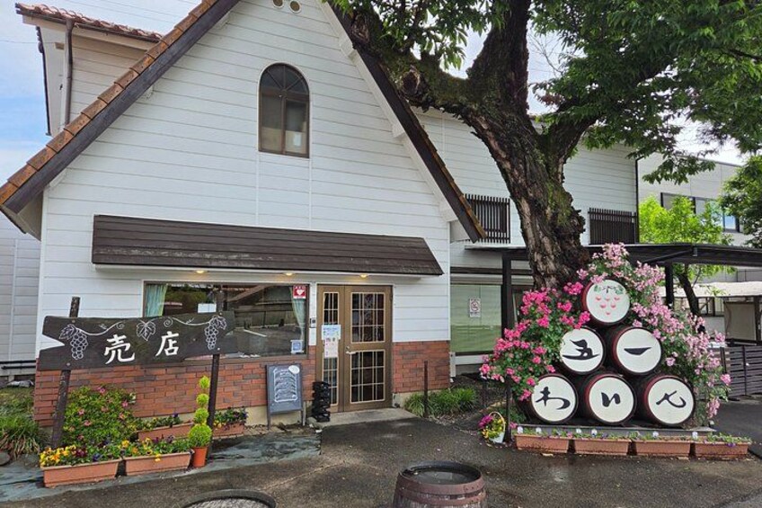A white building with a sign that reads 'KURTEI' and a display of circular signs with Japanese characters. 5