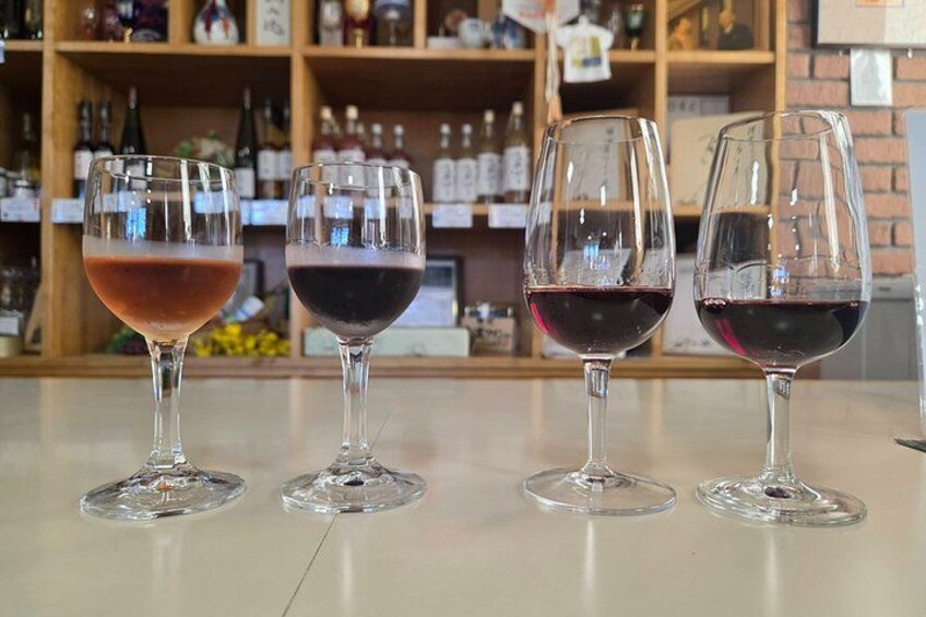 Four wine glasses on a counter with a bar in the background. 1