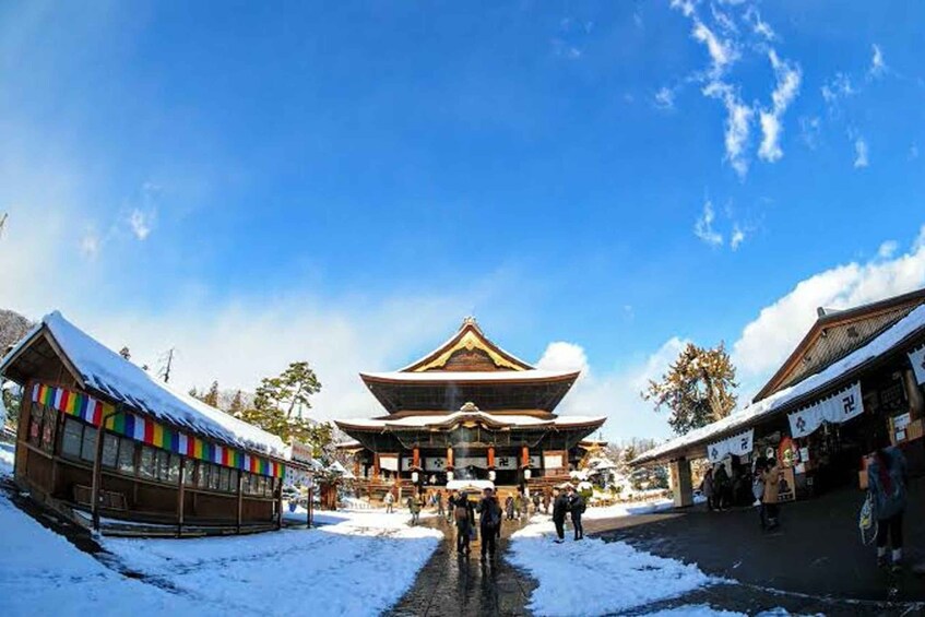 A traditional building with a snow-covered roof, surrounded by a snowy landscape and a clear blue sky. 2