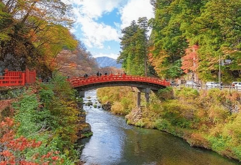 A red bridge over a river surrounded by autumn foliage. 2