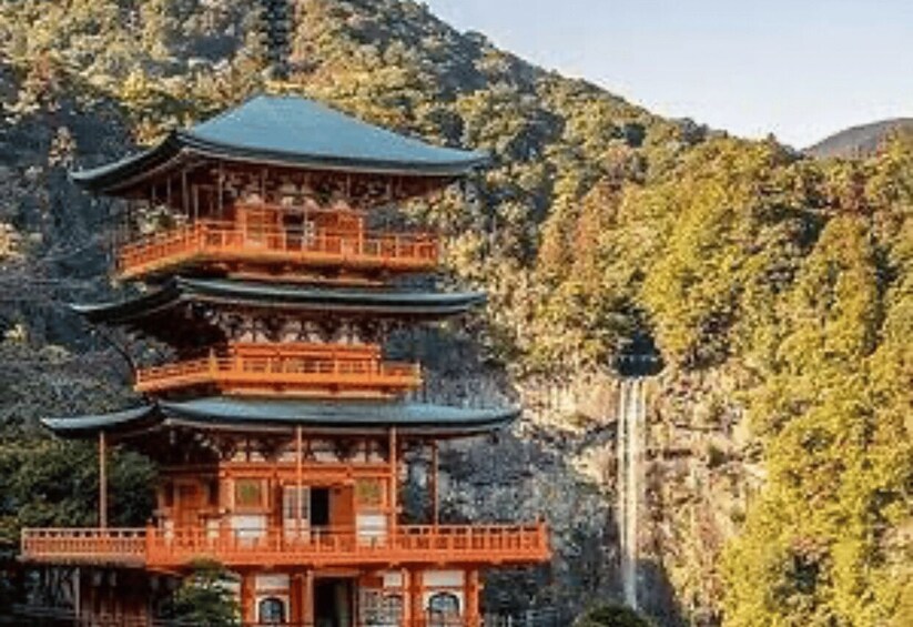 A traditional multi-tiered pagoda with a waterfall in the background. 3