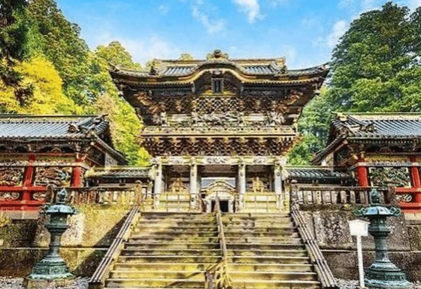 A traditional Japanese temple with ornate architecture, a stone staircase, and lush greenery. 5