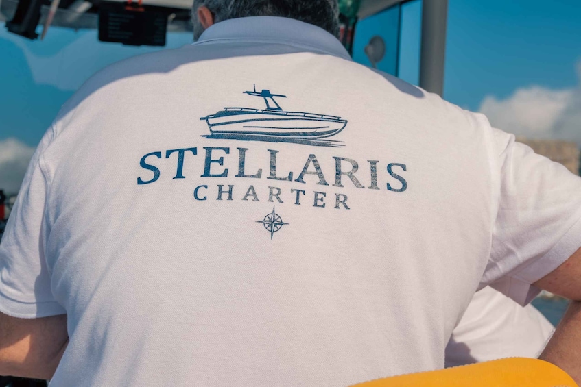A person wearing a white shirt with the text 'STELLARIS CHARTER' and a boat illustration on the back. 2