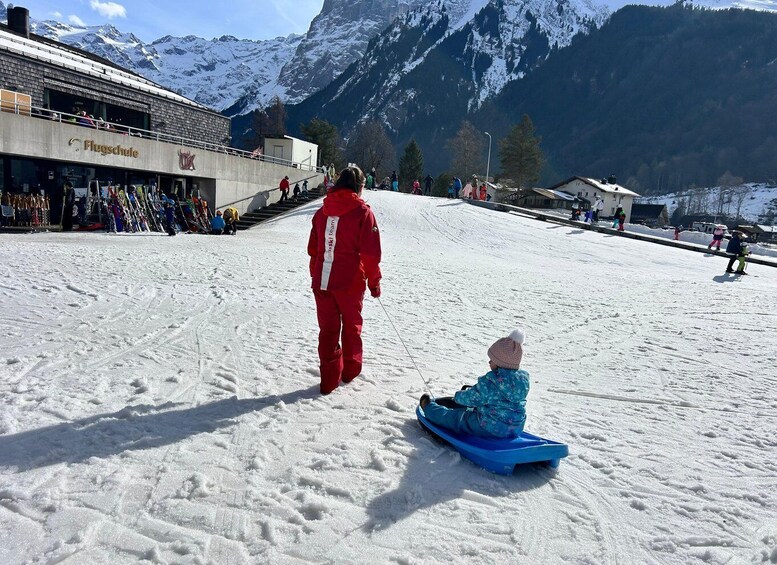 A snowy ski slope with people skiing and snow tubing. 5