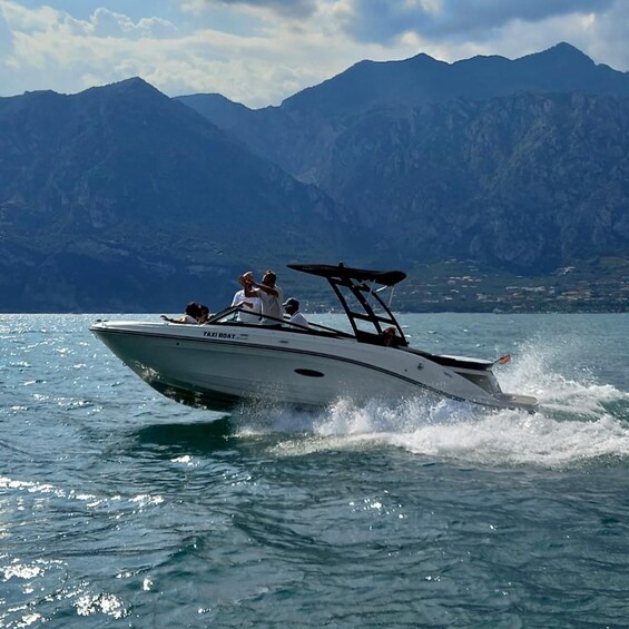A speedboat on a lake with mountains in the background. 1