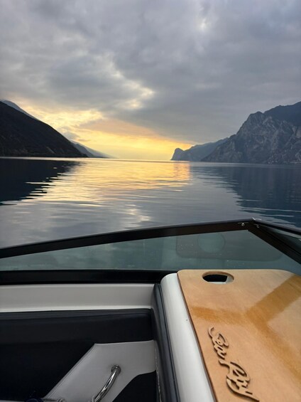 A boat on calm water with mountains in the background and a cloudy sky. 4