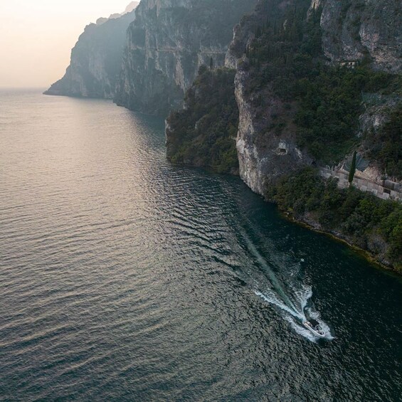 A boat speeding through a narrow waterway flanked by steep cliffs. 3