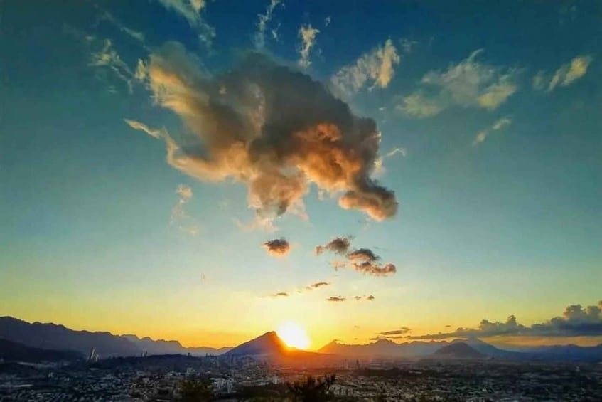 A sunset over a city with mountains in the background. 2