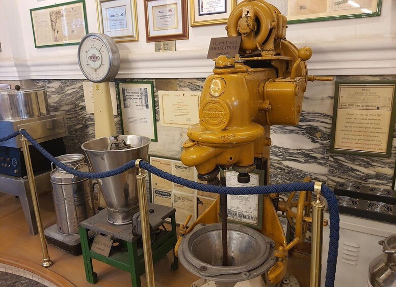 A historical industrial machine with plaques, a scale, and a coffee machine. 3