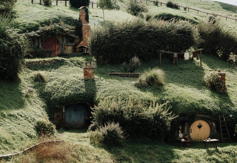 A Hobbiton-style landscape with Hobbit houses, rolling hills, and a wooden fence. 1