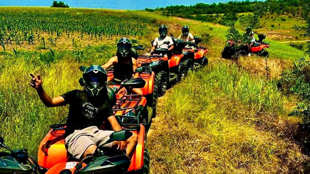 A group of people on ATVs in a grassy field. 4
