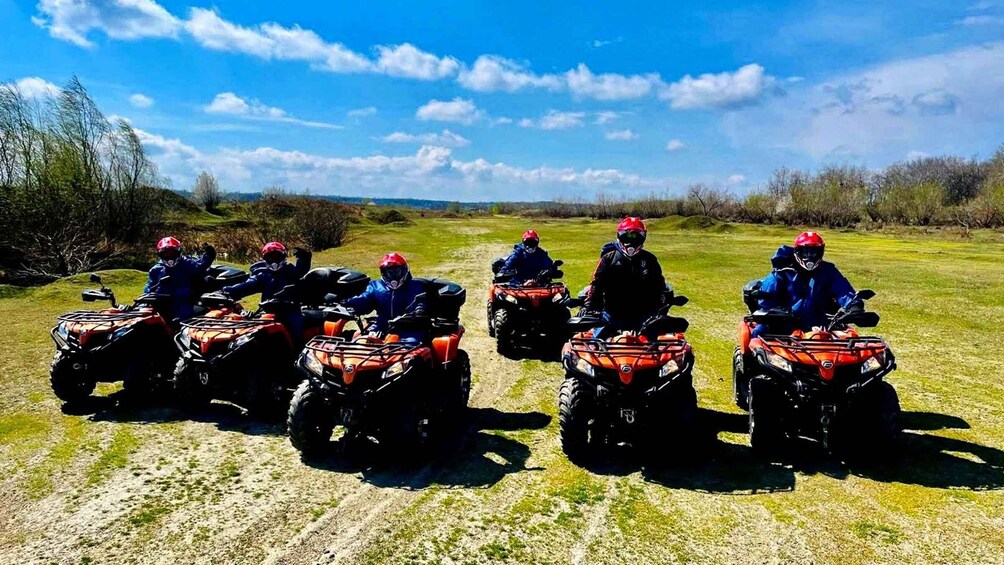 A group of people on ATVs in a grassy field with a clear sky. 2
