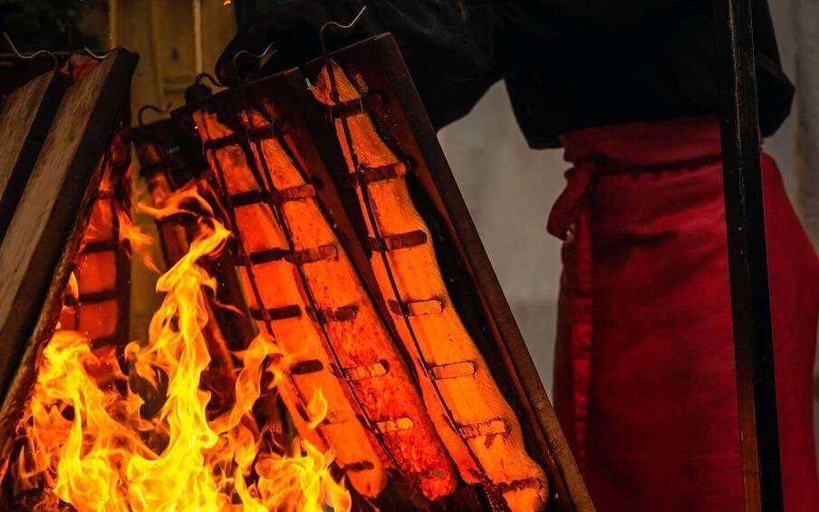 A grill with burning charcoal and flames. 1