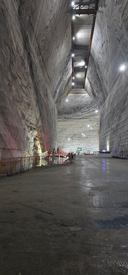 An indoor space with high, marble-like walls and a wet floor, suggesting recent cleaning or rain. 2