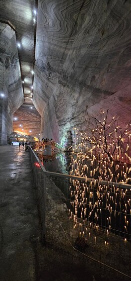 An underground cavern with a wooden fence and hanging lights. 5