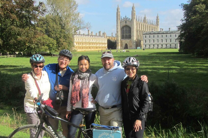 A group of people with bicycles in front of a historic building. 3
