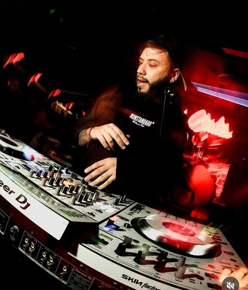 A person operating DJ equipment with a mixer and turntables. 4