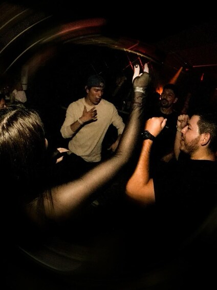 A group of people in a dimly lit environment, possibly a club or party setting. 5