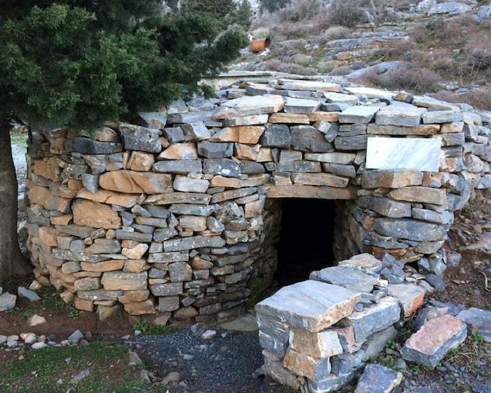 A stone structure with an entrance, surrounded by natural landscape. 1