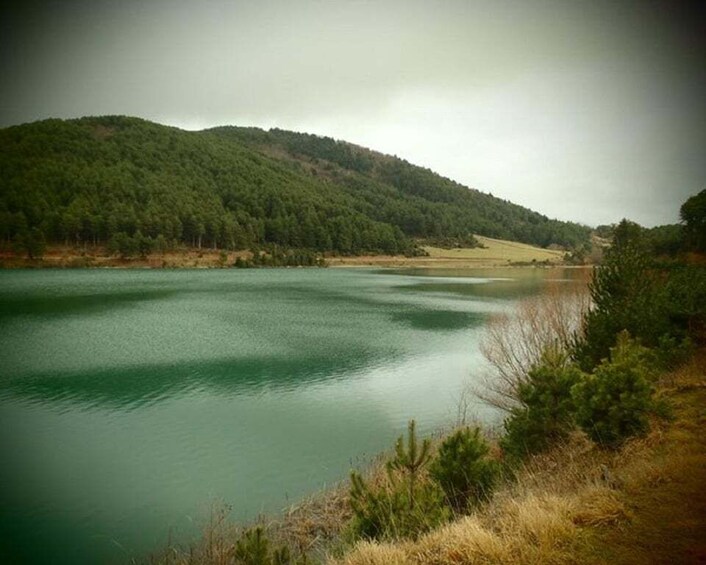 A calm lake surrounded by forested hills. 3