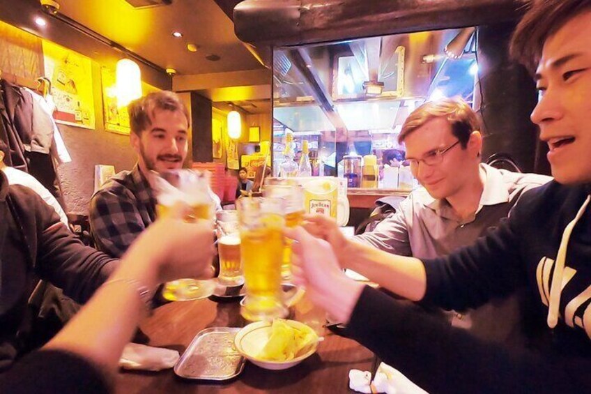 People toasting with beer glasses at a bar. 5