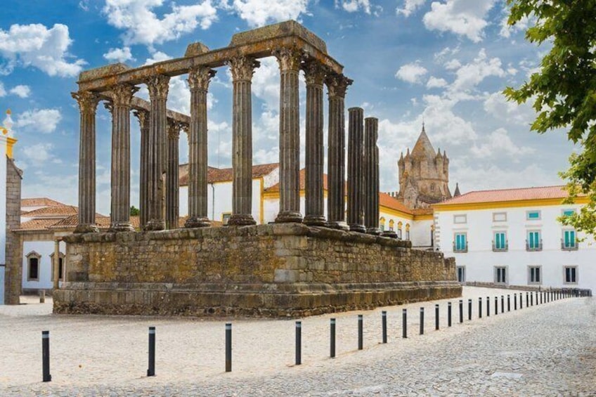 Ancient Roman columns, a cobblestone plaza, and a historic building with a tower. 3