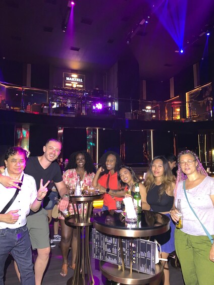 A group of people at a bar with a sign that reads 'MARTELL.' 5