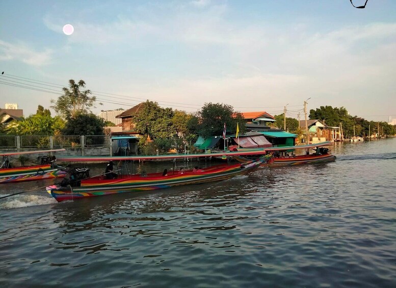 A river with colorful boats, a bridge, and buildings in the background. 4