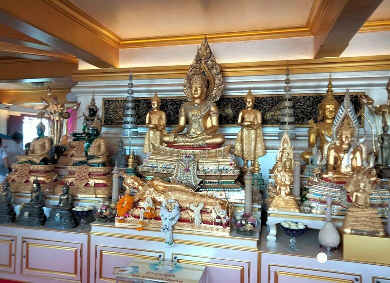 A collection of golden Buddha statues in a temple setting. 3