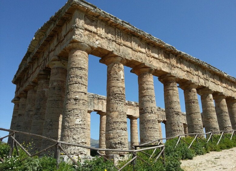 An ancient Greek temple with Doric columns and a partially intact roof. 5