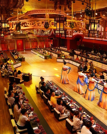 A banquet hall with tables set for a feast, a stage with performers, and traditional decor. 5