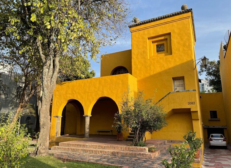 A yellow building with arches and a number '2083' on the side. 4