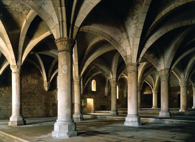 A series of stone arches with columns in a historical building. 5