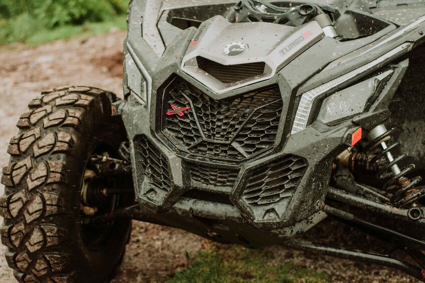 A rugged off-road vehicle with a large, knobby tire, a prominent grille with a red star emblem, and a 'BRP' logo on the front. 5