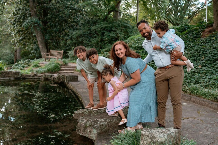 A family by a pond in a park. 2