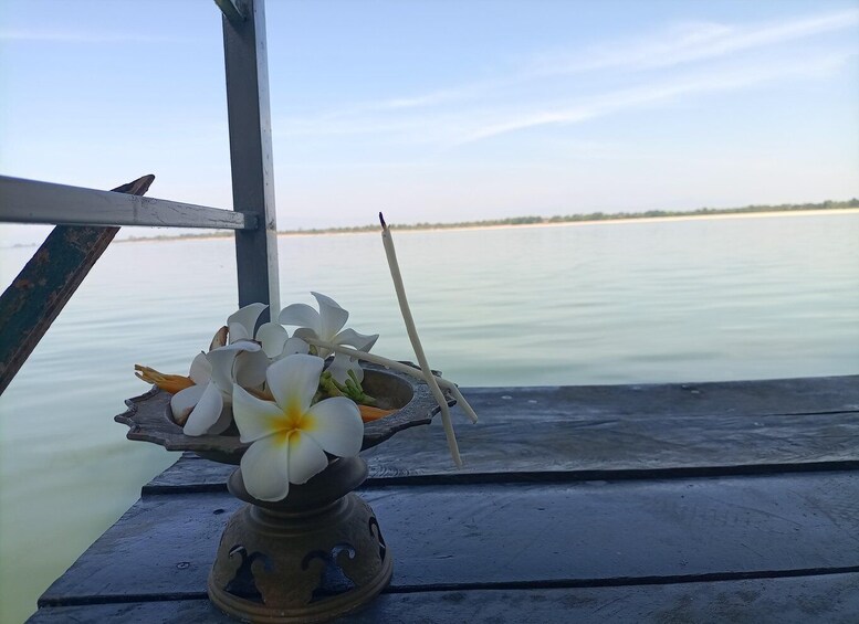 A flower arrangement on a boat deck with calm water and a clear sky. 3