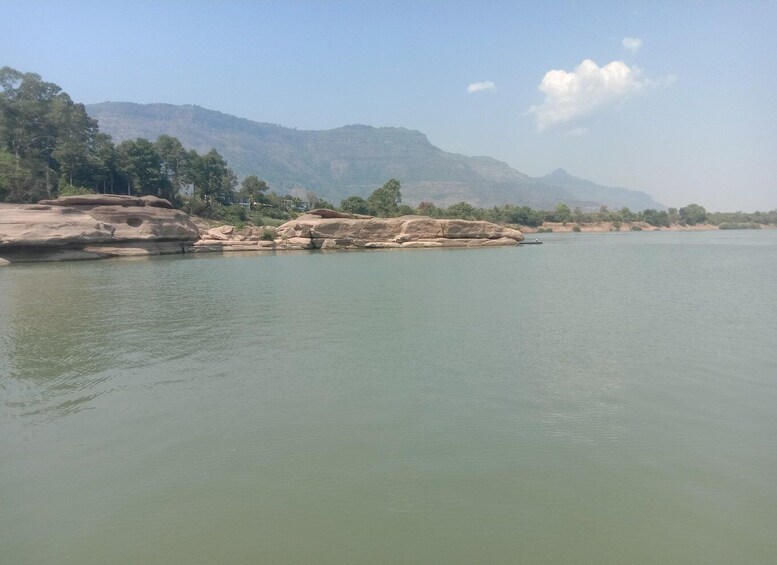 A calm river with rocky banks and distant mountains. 2