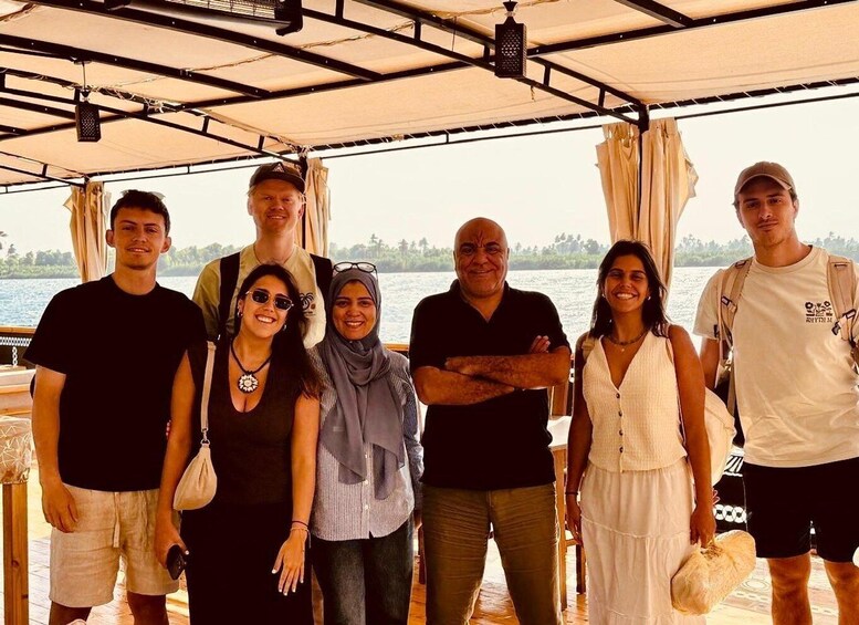 A group of people on a boat with a water body and greenery in the background. 5