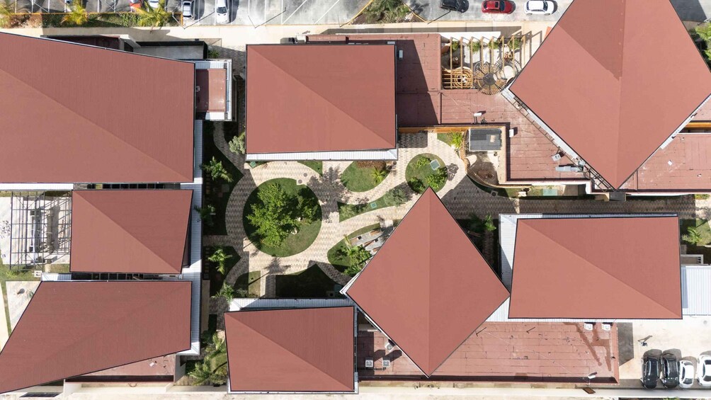 A complex of buildings with large, triangular roofs and a central circular courtyard with trees. 3